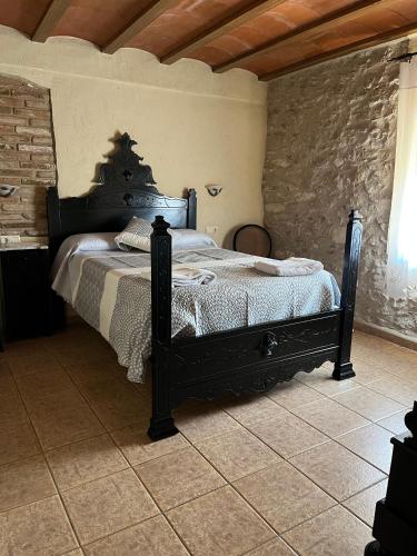 a bedroom with a black bed in a room at Casa Rural Espasa in Espluga de Francolí