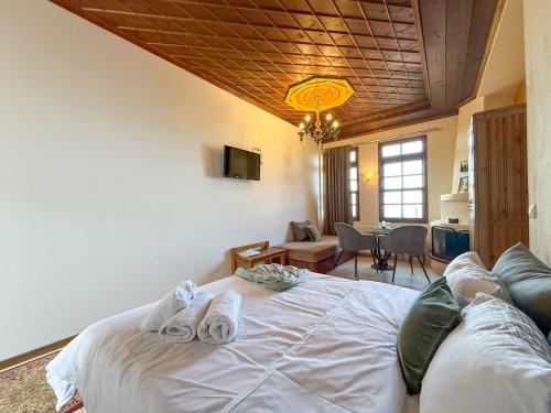 a bedroom with a white bed with towels on it at Pliades Traditional Guesthouse in Palaios Panteleimon