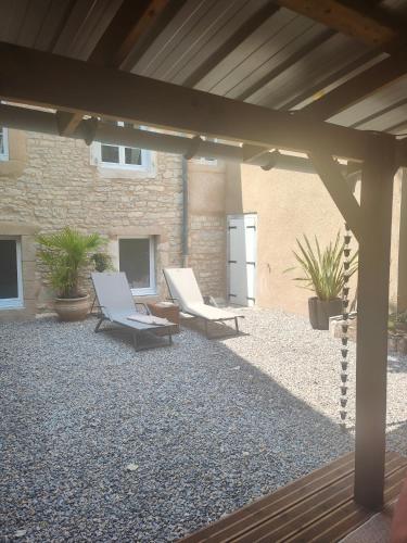 a patio with two lounge chairs and a building at La Marquise des Anges in Martel
