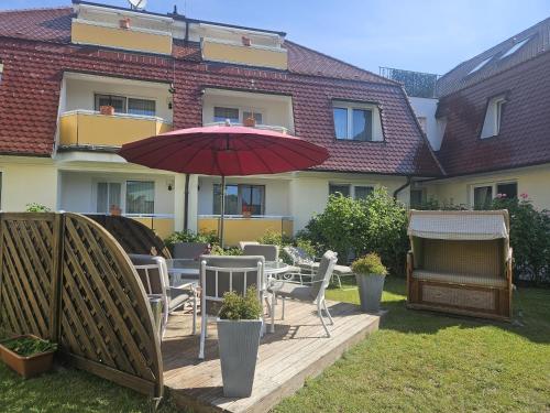 a patio with a table and chairs and an umbrella at Villa Viktoria Whg 20 - "Ostseeloft" in Kölpinsee