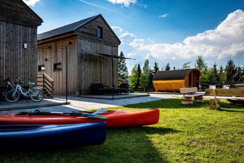 a group of kayaks on the grass next to a barn at Monialuki in Nogat
