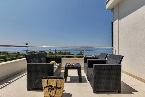 a patio with chairs and a table on a balcony at Villa la Perla in Baška Voda