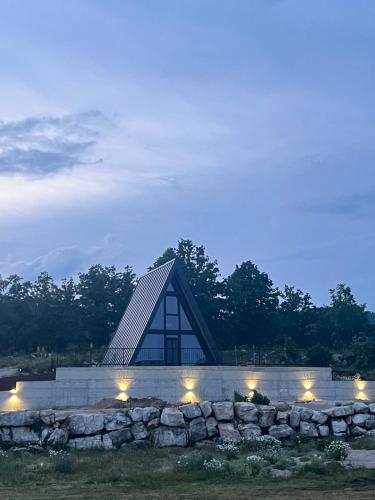 a building with a pyramid roof with a stone wall at Piva Paradise in Pluzine
