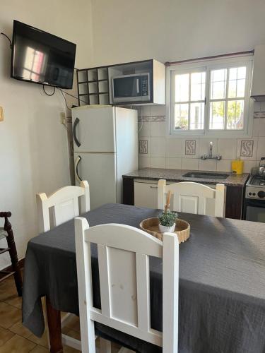 a kitchen with a table and chairs and a kitchen with a refrigerator at Casa en alquiler in Tandil