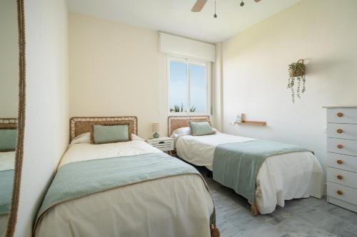una camera da letto con due letti e una finestra di Vistamar Laguna Beach a Torrox Costa