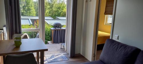 a room with a door open to a balcony with a table and chairs at Tinyhaus Lieblingsplatz in Wemding