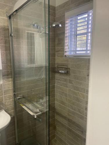 a bathroom with a shower with a glass door at Charming escape in Mandeville