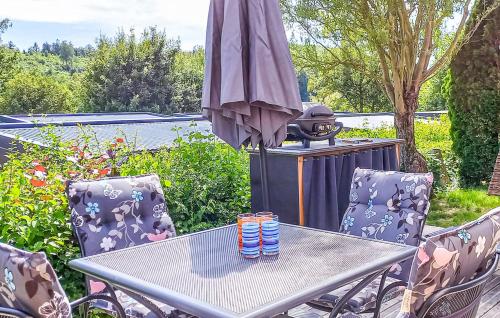 a table with two chairs and an umbrella at Tinyhaus Lieblingsplatz in Wemding