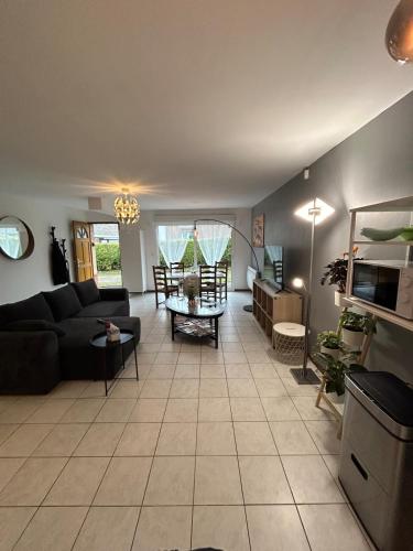 un salon avec un canapé et une table dans l'établissement Maison lumineuse à Lens avec parking gratuit, à Lens