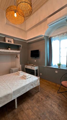 a bedroom with a bed and a tv and a window at Ivy Ayvalık Butik Otel in Ayvalık