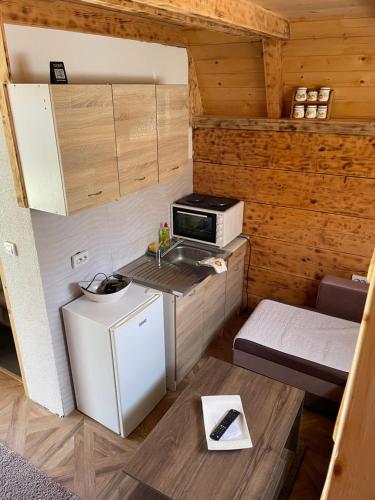 une petite cuisine avec un évier et un micro-ondes dans l'établissement Holiday vikendica, à Žabljak