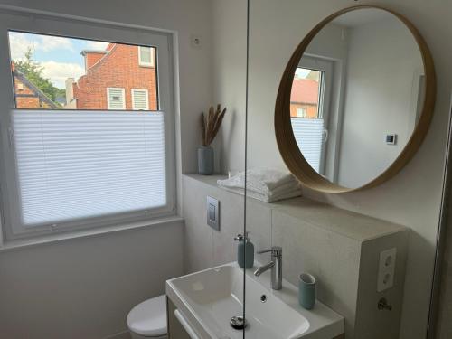 a white bathroom with a mirror and a sink at Ostsee Hotel Travemünde in Travemünde