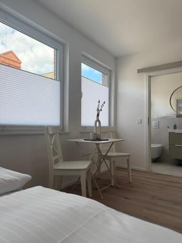 a bedroom with a table and chairs and a bed at Ostsee Hotel Travemünde in Travemünde