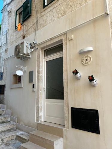 a door on the side of a building with two plants at La Loggetta in Noci