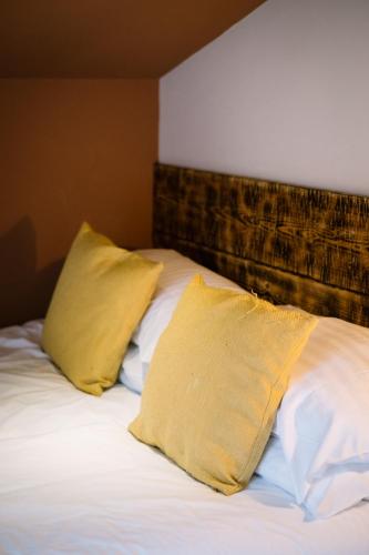 a bed with two yellow pillows on top of it at Luxury Single Small Room Central Location King Bed in Windermere