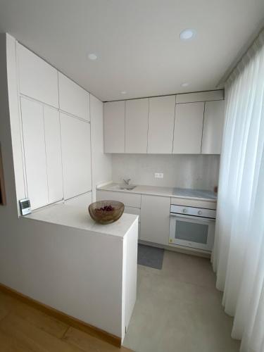 - une cuisine avec des placards blancs et un bol sur un comptoir dans l'établissement Paris 13th Olympiades Apartment, à Paris