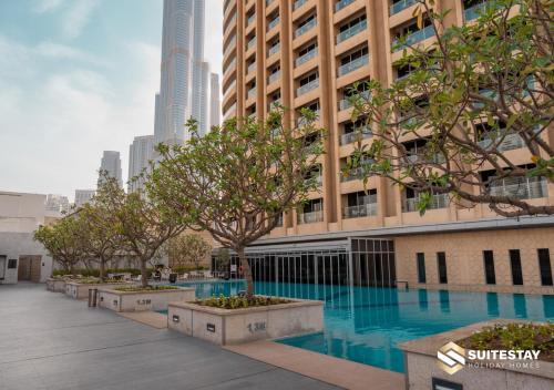 a building with a swimming pool in front of a building at Fashion Avenue Dubai Mall in Dubai