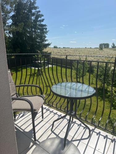 a table and chairs on a balcony with a view of a field at Świat Jezior in Mikołajki