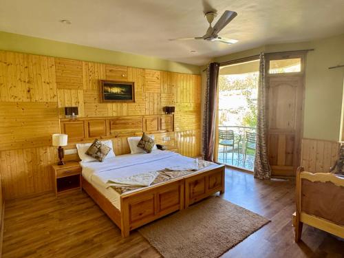 a bedroom with a large bed with wooden walls at Adu's Eternal Comfort in Leh
