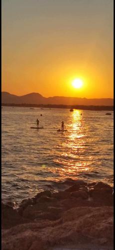 Un groupe de personnes dans l'eau au coucher du soleil dans l'établissement A 30 pas de la Plage, à Canet