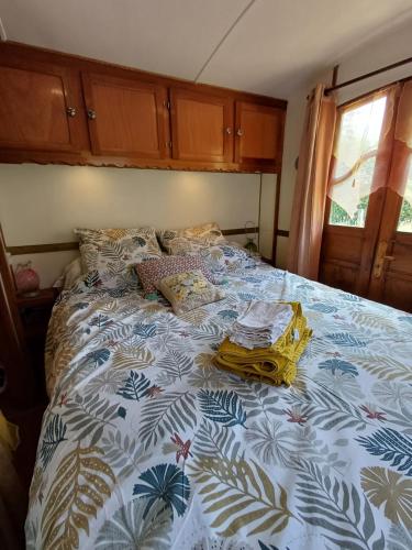 - un lit avec une couette bleue et blanche dans l'établissement Roulotte Mon rêve en Normandie, à Le Mesnil-Garnier