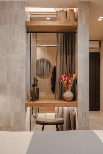 a room with a shelf with a mirror and a chair at Emery Hotel in Naxos Chora