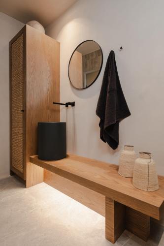 a bathroom with a mirror and a wooden shelf at Emery Hotel in Naxos Chora