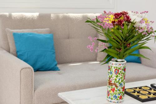 a vase of flowers on a coffee table in front of a couch at Liri family paradise Danis house in Ixia