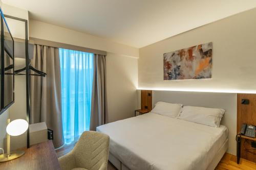 a hotel room with a bed and a chair at Madi city Hotel in LʼAquila