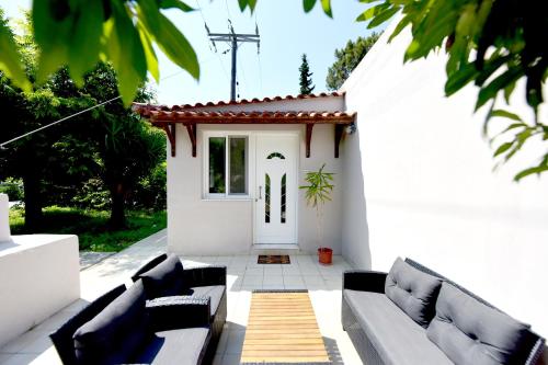 a white patio with couches and a white door at Liri family paradise Danis house in Ixia