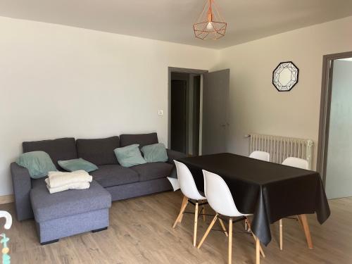 un salon avec un canapé, une table et des chaises dans l'établissement Bas de chalet plein pied, à Villars-Colmars