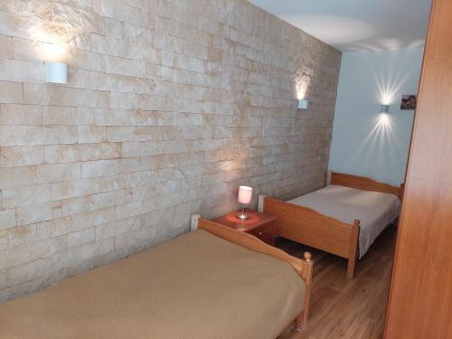 a bedroom with two beds and a brick wall at 2-Zimmerwohnung, 80qm mit Terrasse und großem Garten bei Frankfurt am Main in Bad Vilbel