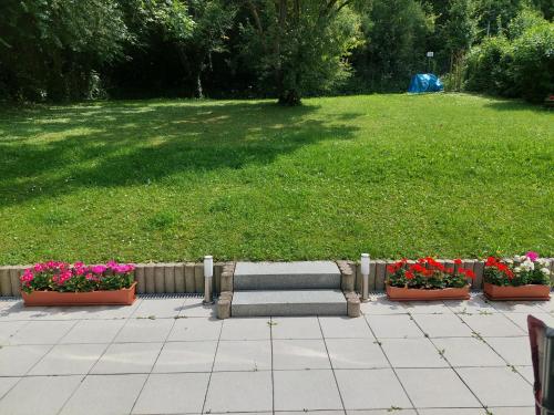 three pots of flowers and a bench in a park at 2-Zimmerwohnung, 80qm mit Terrasse und großem Garten bei Frankfurt am Main in Bad Vilbel