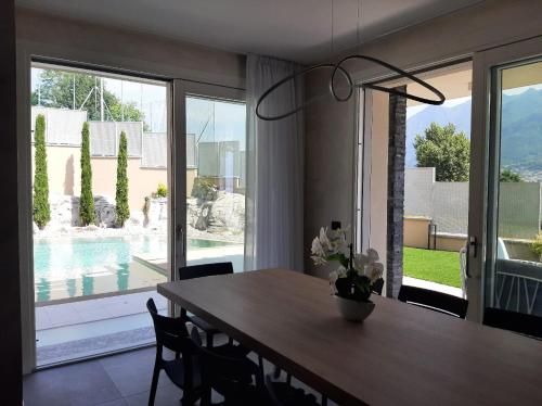 a dining room with a table and a view of a pool at Villa Orchidea in Onno