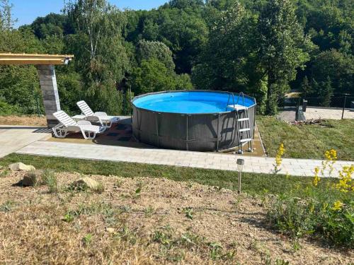 a hot tub in a yard with two chairs and a patio at Vila Fina in Laktaši