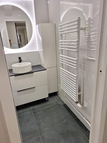 a white bathroom with a sink and a mirror at Chambre d'hôtes Paris La défense Arena in Puteaux