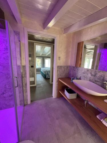 a bathroom with a sink and a shower with purple lighting at Villa Orchidea in Onno