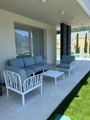 a patio with chairs and a couch and a table at Villa Orchidea in Onno