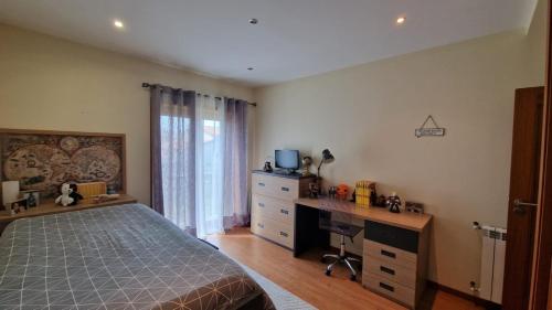 a bedroom with a bed and a desk with a computer at Maria Vagueira BeachHouse in Vagos