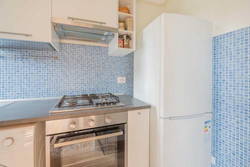 a kitchen with a stove and a white refrigerator at Windrose Atelier in Marina di Pisa