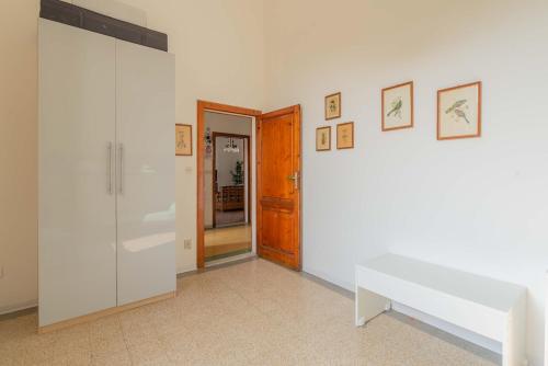 a white room with a bench and a door at Windrose Atelier in Marina di Pisa