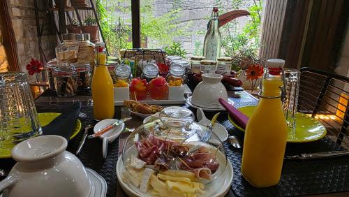 - une table avec des assiettes de nourriture et des bouteilles de jus dans l'établissement D'Ici et D'Ailleurs, à Cordes-sur-Ciel