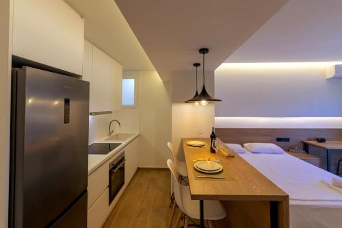 a kitchen with a wooden table and a refrigerator at Anna's Lovely Corfu Studio in Corfu