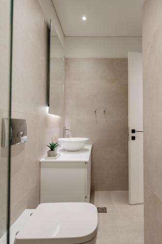 a white bathroom with a sink and a toilet at Anna's Lovely Corfu Studio in Corfu