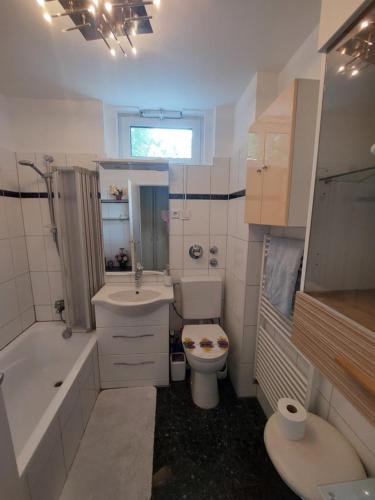 a white bathroom with a toilet and a sink at 2-Zimmerwohnung, 80qm mit Terrasse und großem Garten bei Frankfurt am Main in Bad Vilbel