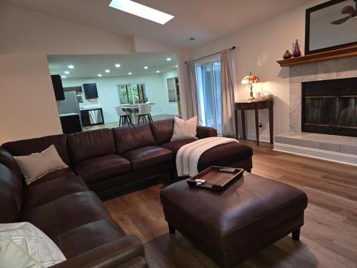 a living room with a leather couch and a fireplace at Spacious & Serene 3 bedrooms in New Bern