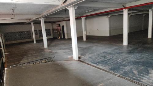 an empty room with white columns in a building at Hostel Nova Jerusalém in Cianorte