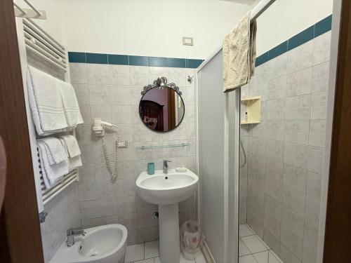 Un baño blanco con lavabo y espejo. en Casa Pianalto, en Tricase