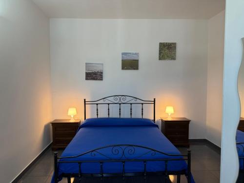 Un dormitorio con una cama azul con dos mesitas de noche. en Casa Pianalto, en Tricase