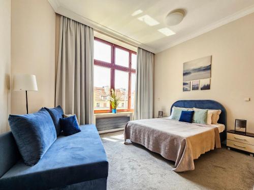 une chambre avec un lit et un canapé bleu dans l'établissement Historic Market Square Suite -140m2 Grand Residence AS Home Apartamenty R504, à Wrocław